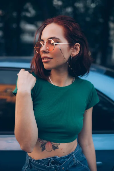 戴眼镜的年轻女子站在车边 — 图库照片