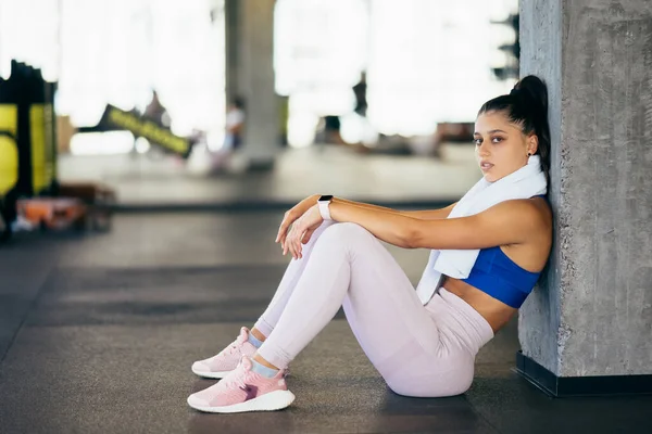 健康的年轻女性在健身房训练后放松了下来 在健身房锻炼后休息的妇女 — 图库照片