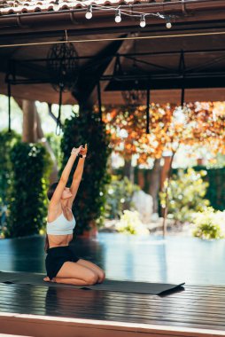 Genç kadın tek başına yoga yapıyor.