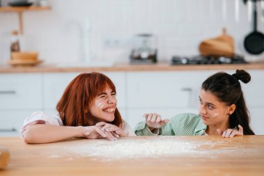 Kadınlar mutfakta unla oynarlar.