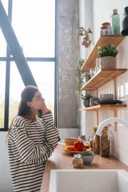 Mutfakta masanın yanında duran kadın.