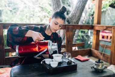 Çay demleme işlemi. Kadın bitki çayı demliyor ve sakin bir öğleden sonranın tadını çıkarıyor..