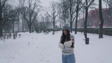 Genç bir kadın parkta üşüyormuş. Her tarafı karla kaplıymış.