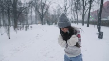 Genç bir kadın parkta üşüyormuş. Her tarafı karla kaplıymış.