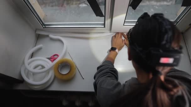 Жінка Приклеює Герметичну Гумову Стрічку Вікно Приміщенні — стокове відео
