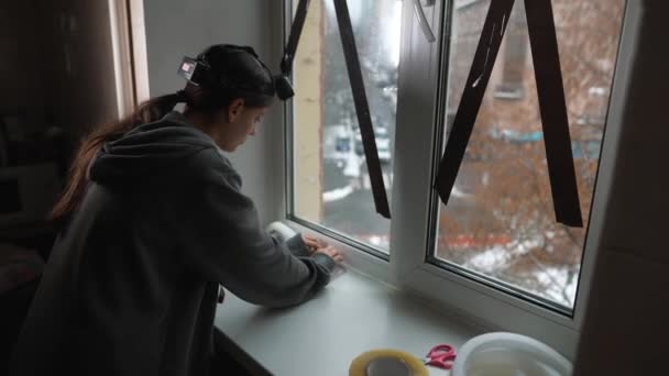 Жінка Приклеює Герметичну Гумову Стрічку Вікно Приміщенні — стокове відео