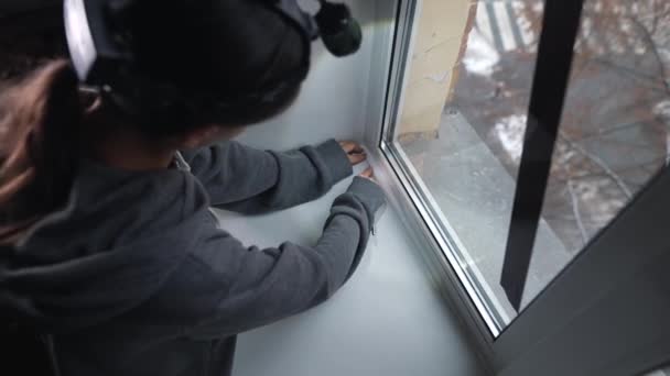 Kobieta Przykleja Gumową Taśmę Uszczelniającą Okna Wewnątrz — Wideo stockowe