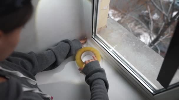 Une Jeune Femme Scelle Fenêtre Avec Ruban Adhésif Intérieur — Video