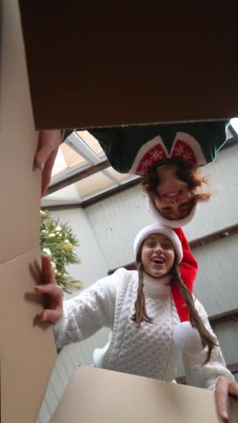 Νεαρές Χαρούμενες Γυναίκες Χριστουγεννιάτικα Καπέλα Ανοίγουν Χαρτόκουτα Και Κοιτάζουν Μέσα — Αρχείο Βίντεο