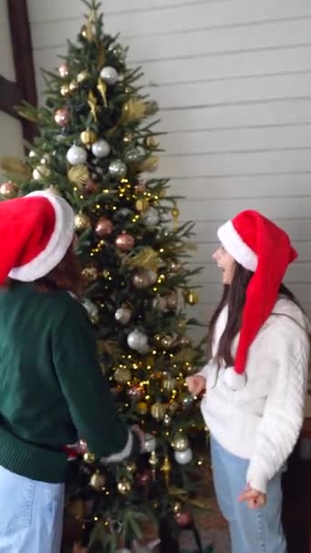 Mutlu Genç Kadınlar Dekore Edilmiş Stüdyo Odasında Noel Ağacının Yanında — Stok video