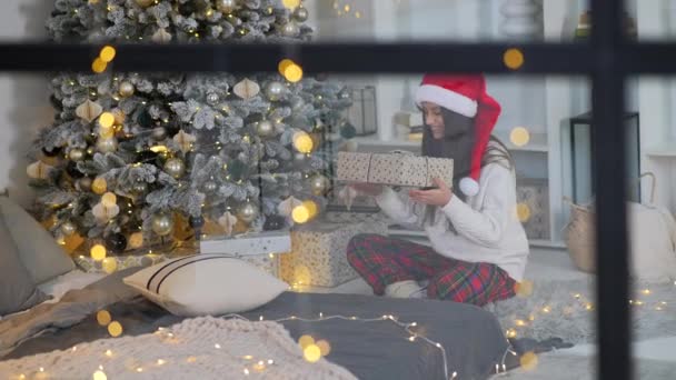 Olhando Pela Janela Jovem Segurando Presente Perto Árvore Natal — Vídeo de Stock