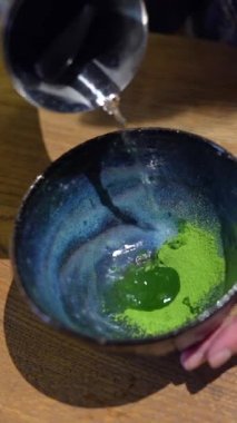 Japon matcha latte 'si yapmak, çay bambu çırpıcısıyla çırpılır, geleneksel kibrit çöpü..