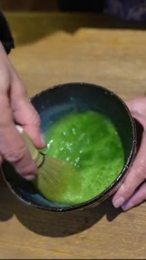 Japon matcha latte 'si yapmak, çay bambu çırpıcısıyla çırpılır, geleneksel kibrit çöpü..