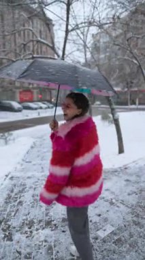 Güzel gülümseyen kadın kar tanelerini elleriyle yakalar.