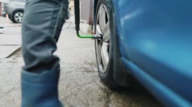 Adamın araba tekerleği vidalama yatay görüntüle
