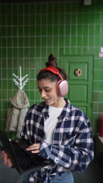 Hermosa Chica Los Auriculares Está Hablando Escribiendo Ordenador Portátil Cafetería — Vídeo de stock