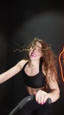 Spor salonunda eliptik yörünge makinesinde koşan bir kadın. Ağır çekim. Yüksek kaliteli FullHD görüntüler
