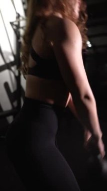 Kafkasyalı kadının kol kaslarını çalıştırmak için ağır dambılı kaldırdığı yakın çekim. Spor salonundaki kadın sporcunun portresi. Yüksek kalite 4K görüntü. Yüksek kaliteli FullHD görüntüler