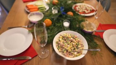 Yakın çekimde, arkadaşlarının yemek masasını lezzetli yemeklerle kutluyorlar. Noel 'de parti masasında yemek ve içecek konsepti 4K görüntüler. Yüksek kalite 4K görüntü. Yavaş çekim