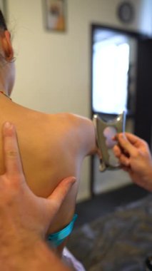 Doktor IASTM bıçağını kadınlar üzerinde uyguluyor. Doktor sporcu iyileşme kaslarına yardımcı oluyor. Yüksek kalite 4k görüntü