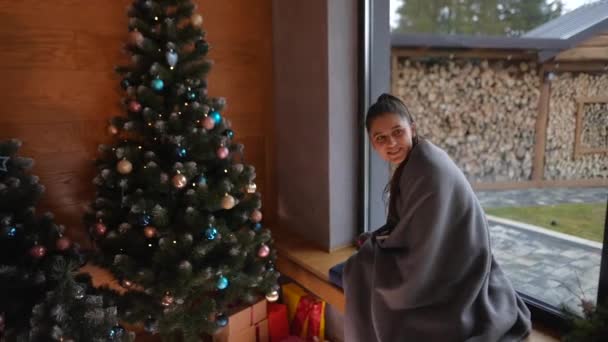 Schöne Junge Mädchen Kariertem Lächeln Sitzt Neben Geschmückten Weihnachtsbaum Hause — Stockvideo