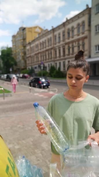 年轻的成年女孩把一个塑料瓶扔进一个特殊的容器 回收塑料 对垃圾进行适当分类 高质量的4K镜头 — 图库视频影像