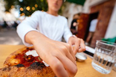 Terasta pizzası olan genç bir kadının portresi.. 