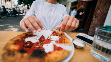 Terasta pizzası olan güzel genç bir kadın.. 