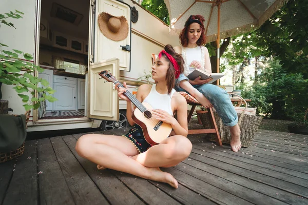 stock image Happy hippie friends are having a good time together in camper trailer. Holiday, vacation, trip concept. High quality photo