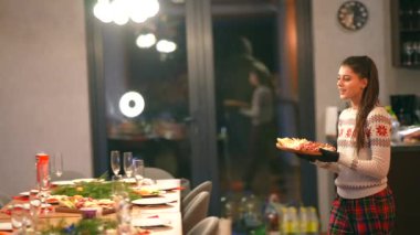 Tahta masada Noel partisi için yemek hazırlayan güzel bir kız. Yüksek kalite 4k görüntü