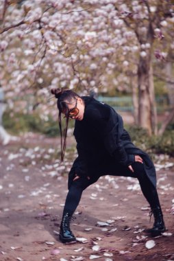 Siyah kimono giyen, kiraz çiçekli sarı gözlüklü, sakura manzaralı güzel, dramatik bir genç kadın. Yüksek kalite fotoğraf