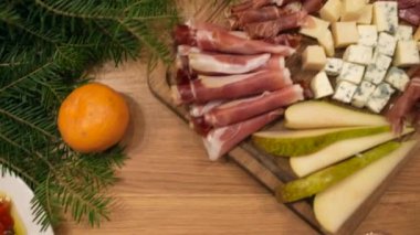 Yakın çekimde, arkadaşlarının yemek masasını lezzetli yemeklerle kutluyorlar. Noel 'de parti masasında yemek ve içecek konsepti 4K görüntüler. Yüksek kalite 4k görüntü