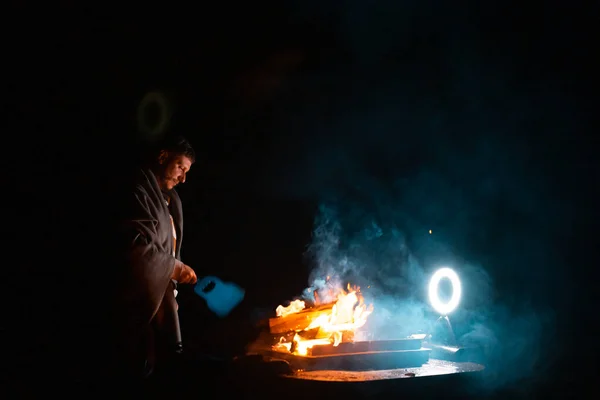 准备烤肉烤架生火的人 外面的黑暗镜头 枪林弹雨高质量的照片 — 图库照片
