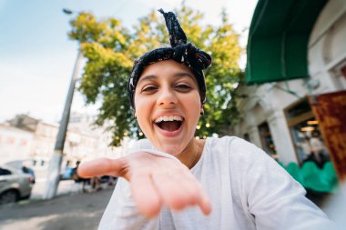 Kamerada selfie çeken bir kızın güneşli görüntüsü, çılgınca duygular. 