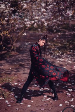 Kiraz çiçekli kimono giyen güzel, dramatik genç bir kadın, sakura manzaralı. Yüksek kalite fotoğraf