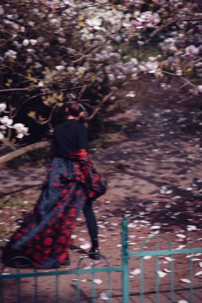 バックビュー美しい劇的な若い女性は 桜の花 桜のビューで彼女の顔を隠すために手を上げて着物を着て 高品質の写真 — ストック写真