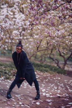 Siyah kimono giyen, kiraz çiçekli sarı gözlüklü, sakura manzaralı güzel, dramatik bir genç kadın. Yüksek kalite fotoğraf