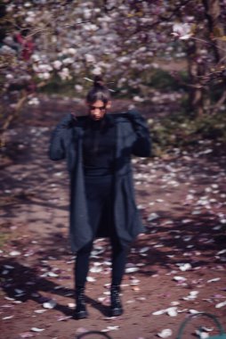 Kiraz çiçekli kimono giyen güzel, dramatik genç bir kadın, sakura manzaralı. Yüksek kalite fotoğraf