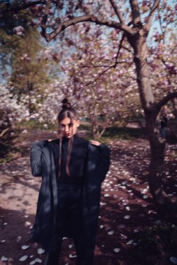 Kiraz çiçekli kimono giyen güzel, dramatik genç bir kadın, sakura manzaralı. Yüksek kalite fotoğraf