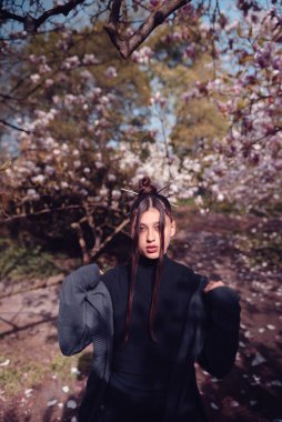 Kiraz çiçekli kimono giyen güzel, dramatik genç bir kadın, sakura manzaralı. Yüksek kalite fotoğraf