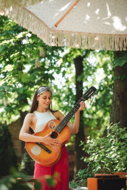 Mutlu hippi kız karavanda gitar çalarak iyi vakit geçiriyor. Tatil, tatil, gezi konsepti. Yüksek kalite fotoğraf.