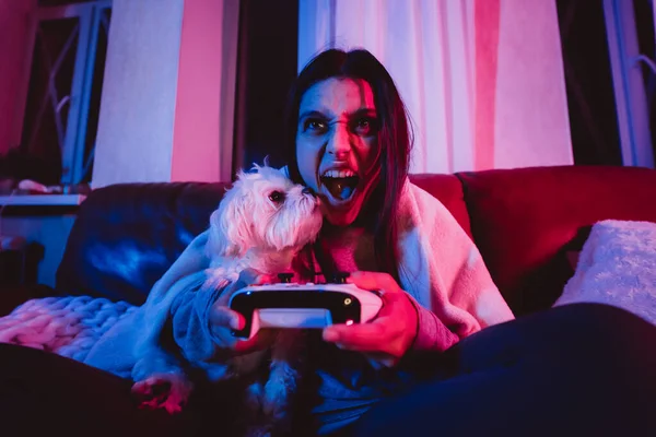 Uma Mulher Jovem Está Jogando Um Console Do Jogo. Jogo Da Menina E Jogos De  Vídeo Do Computador. O Streamer Segura Um Joystick Em Suas Mãos. Pessoa Em  Casa À Noite Foto