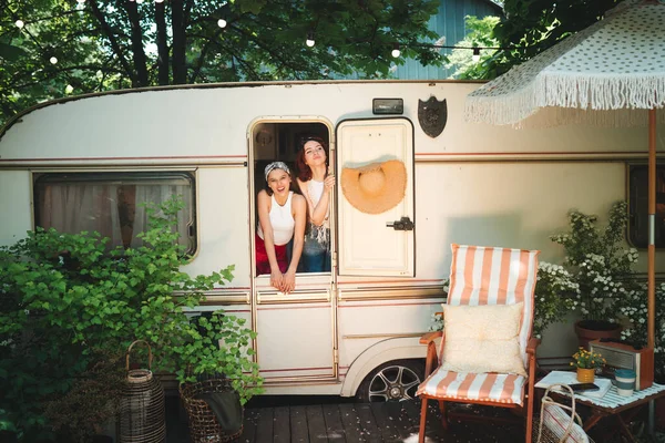 stock image Happy hippie friends are having a good time together in a camper trailer. Holiday, vacation, trip concept. High quality photo