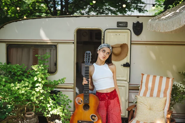 快乐的嬉皮士女孩在露营拖车上弹奏吉它很开心 旅行的概念 高质量的照片 — 图库照片