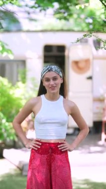 The beautiful hippie girl is talking in front of the trailer. High quality 4k footage