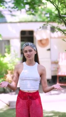 The beautiful hippie girl is talking in front of the trailer. High quality 4k footage