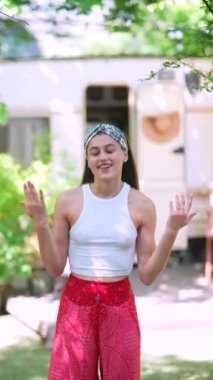 The beautiful hippie girl is talking in front of the trailer. High quality 4k footage