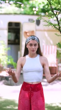 The beautiful hippie girl is talking in front of the trailer. High quality 4k footage