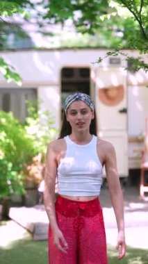 The beautiful hippie girl is talking in front of the trailer. High quality 4k footage