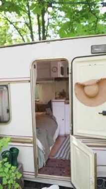 The camera slowly zooms in inside the trailer, where two hippie girls are happily chatting with a laptop in their hands. High quality 4k footage